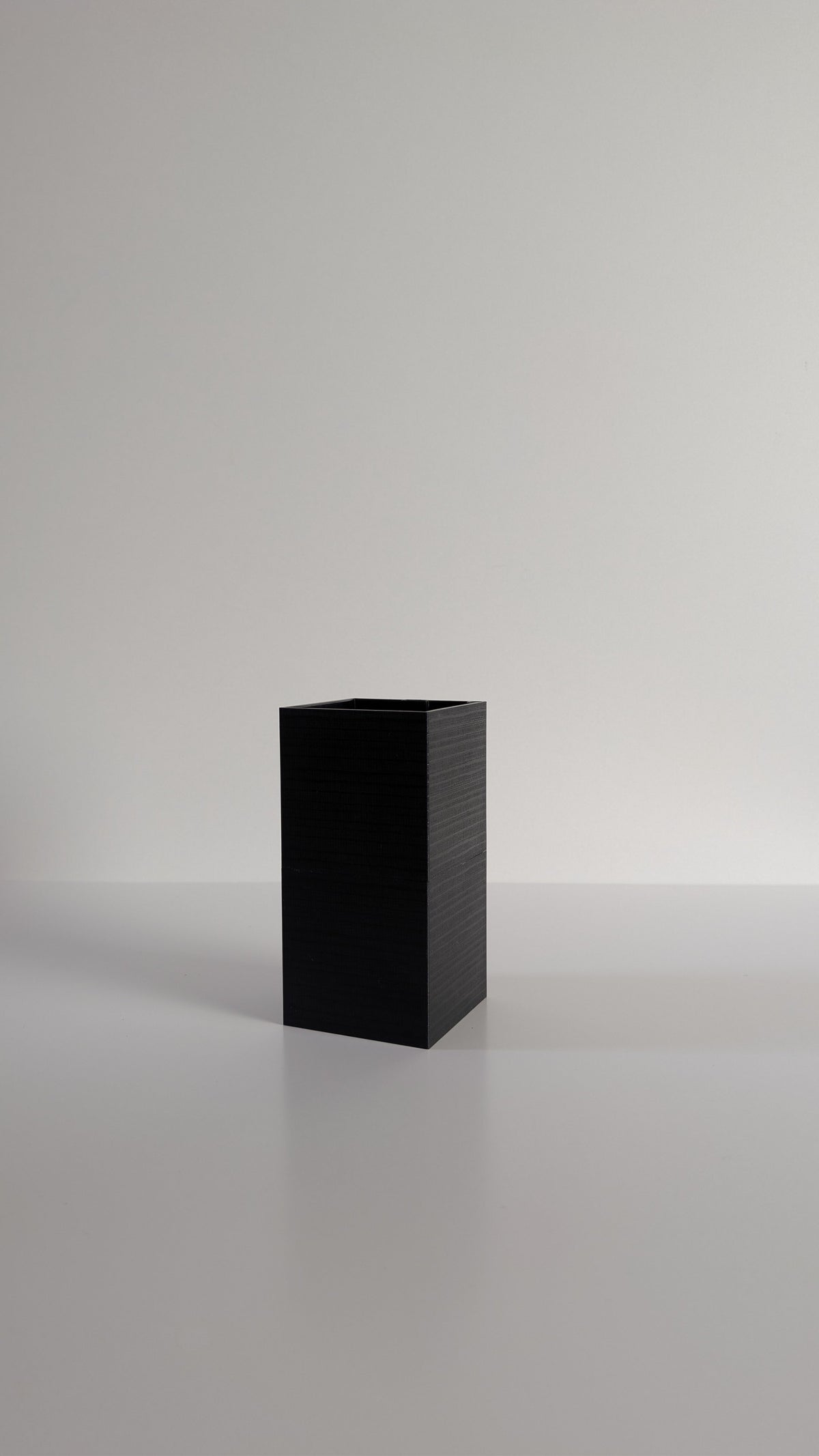 Cache-pot à arrosage autonome Le Cube Éclance noir, sans plante, sur fond neutre