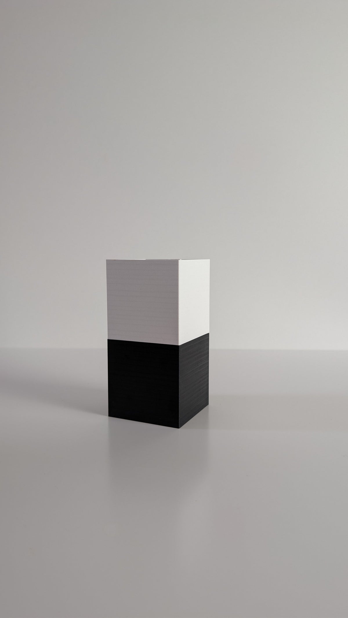Cache-pot à arrosage autonome Le Cube Éclance bicolore, module haut blanc et module bas noir, sans plante, sur fond neutre