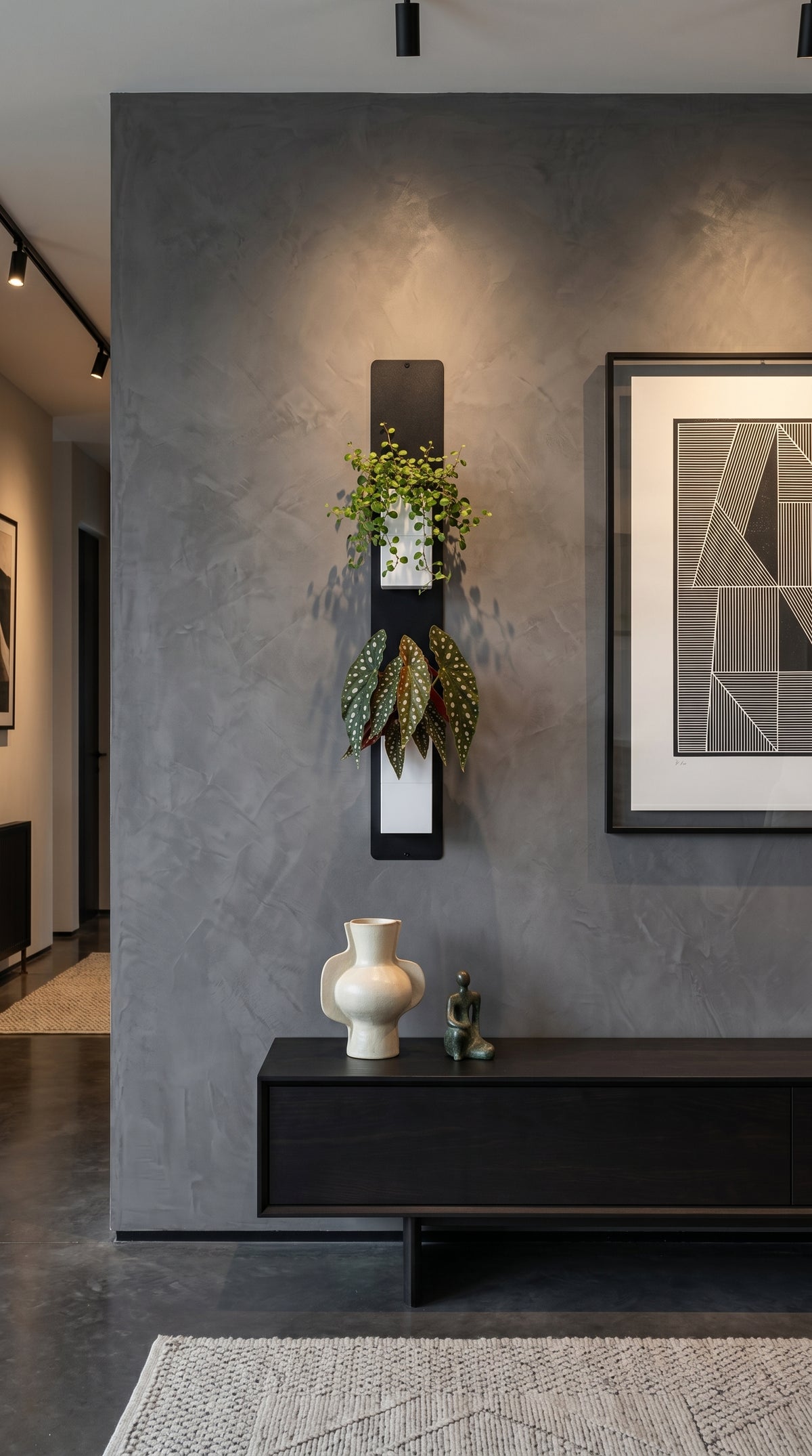 Support mural noir Éclance décoration intérieur végétal accueillant deux cache-pots blancs Le cube (adaptés pour un pot de 6cm) avec plantes vertes, installé sur un mur texturé gris foncé au-dessus d’un enfilade noire.