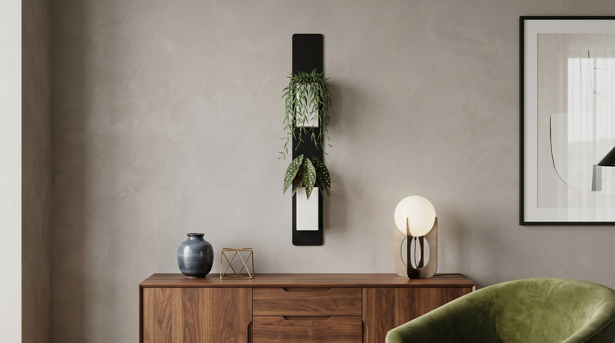 Support mural noir Éclance décoration intérieur végétal avec deux cache-pots blancs Le cube, adaptés pour un pot de 6cm, fixés au-dessus d’un buffet en bois au design épuré.