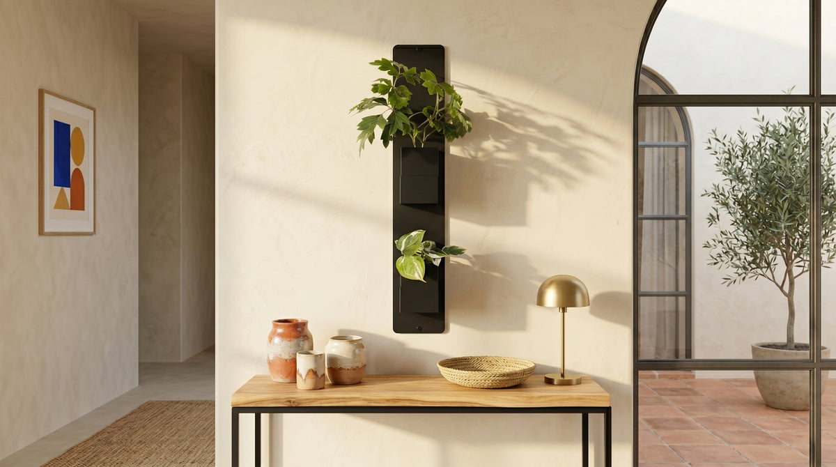 Support mural noir Éclance décoration intérieur végétal avec deux cache-pots noirs Le cube (adaptés pour un pot de 6cm), fixé au-dessus d’une console en bois avec une lampe dorée, à côté d'une verrière en arche.