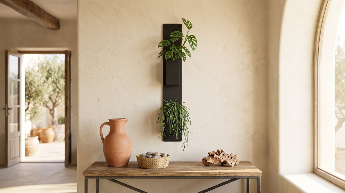 Support mural noir Éclance décoration intérieur végétal équipé de deux cache-pots noirs Le cube (adaptés pour un pot de 6cm), installé sur un mur texturé beige au-dessus d’une console en bois avec une cruche en terre cuite.