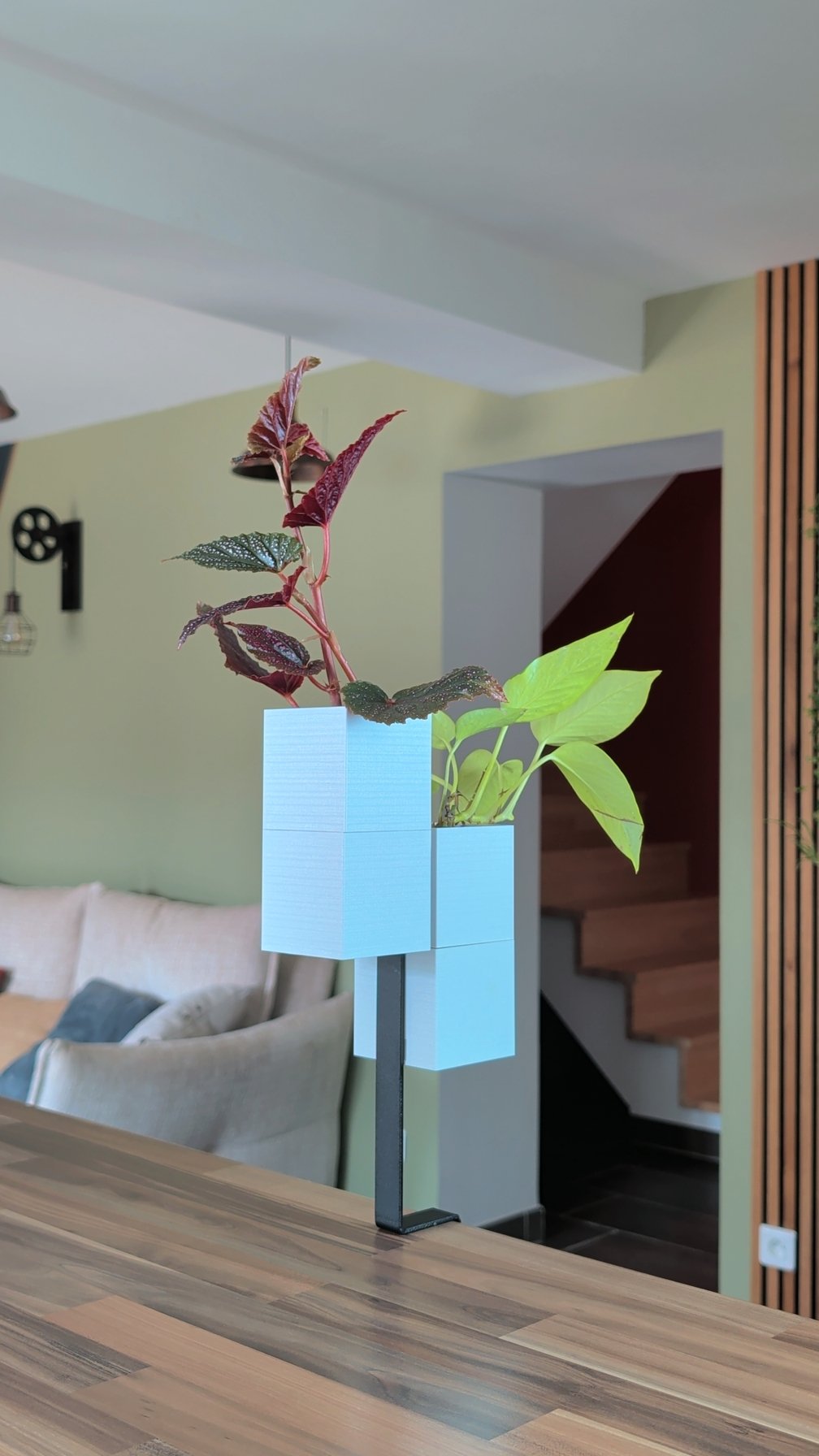 L'Îlot Végétal Éclance double blanc : support pour plantes Îlot Végétal blanc fixé sur un comptoir dans un salon moderne.