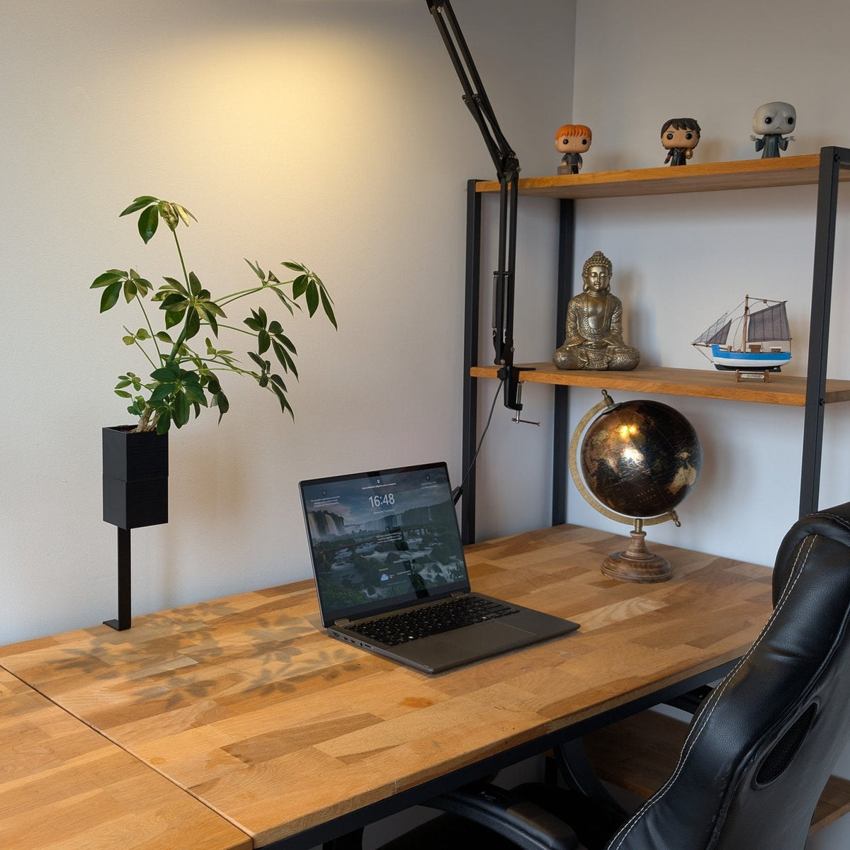 L'Îlot Végétal Éclance simple noir : un bureau en bois aménagé avec un ordinateur portable, une étagère et deux pots de plantes noirs.