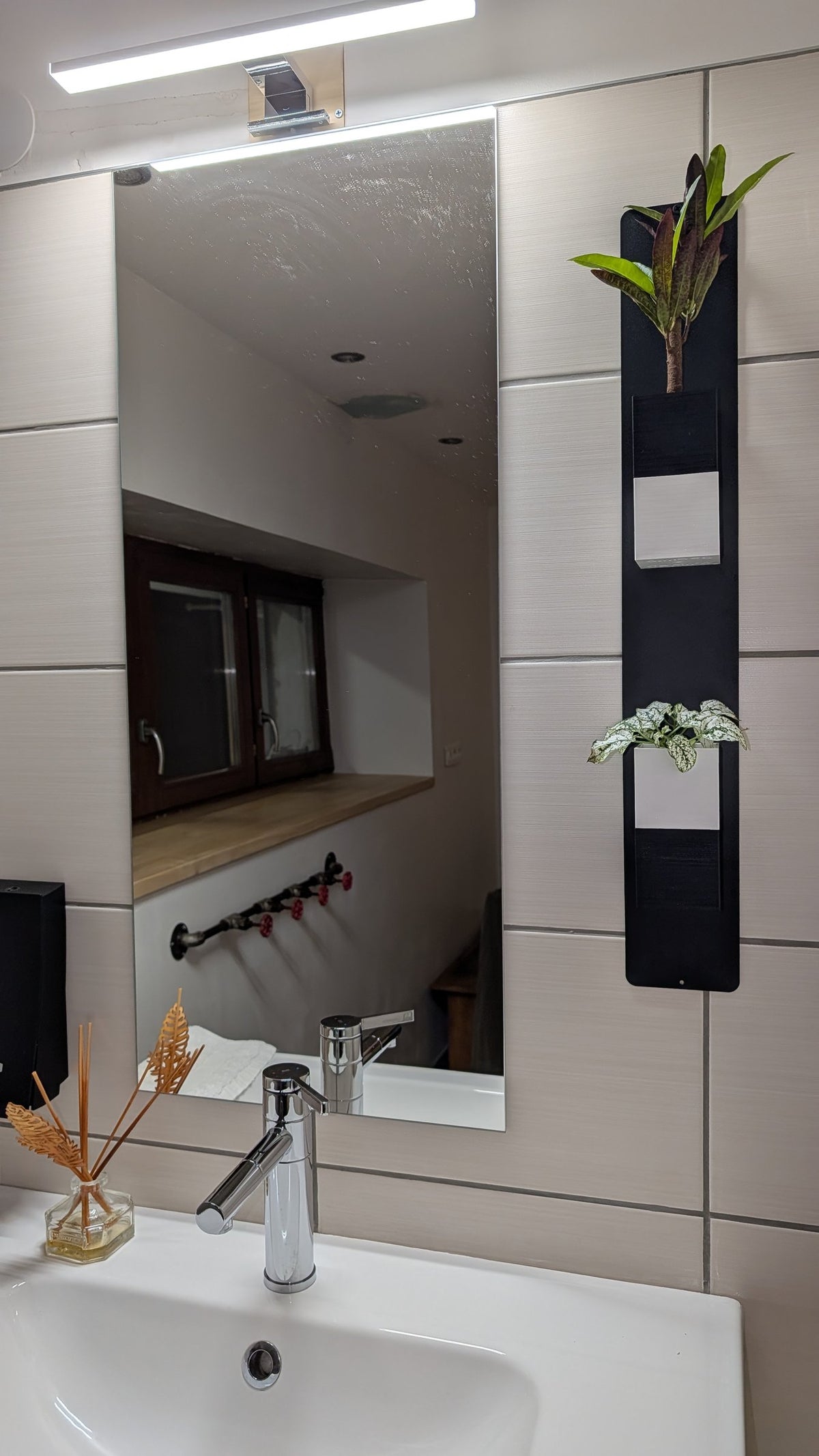 Mini mur végétal Éclance M2 bicolore noir et blanc : support mural végétal bicolore installé à côté d'un miroir dans une salle de bain moderne.