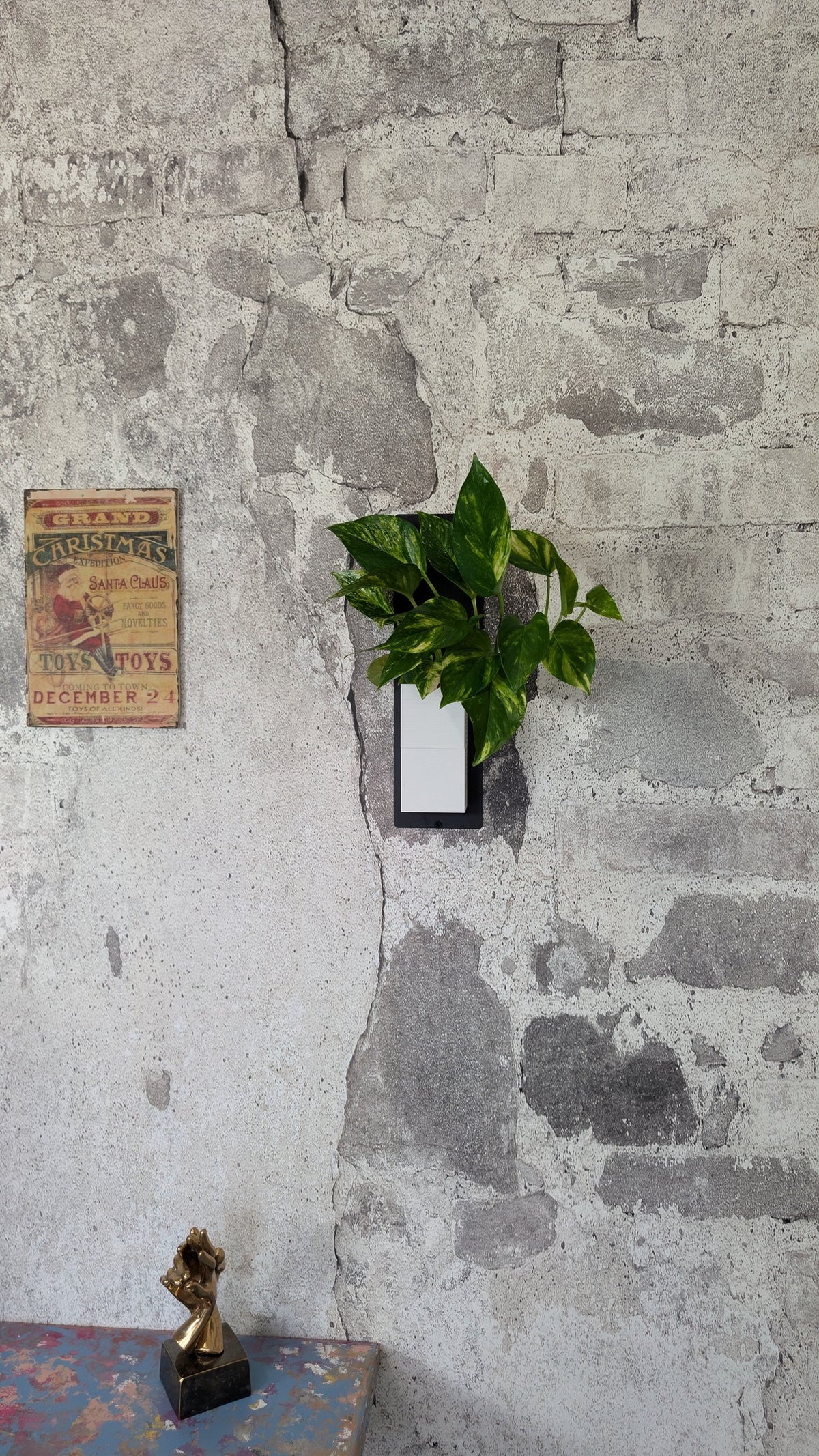 Mini mur végétal Éclance M1 blanc : support mural Mini Mur blanc fixé sur un mur en briques anciennes avec une plante verte.