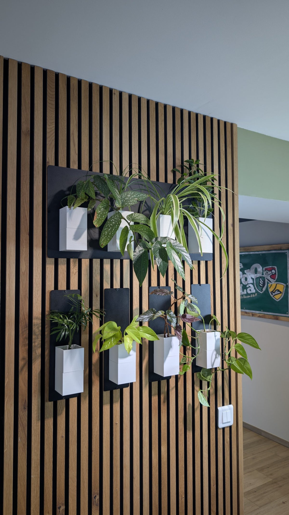 Mur végétal Éclance XS blanc : mur végétal Éclance blanc et noir installé sur un bardage en tasseaux de bois.